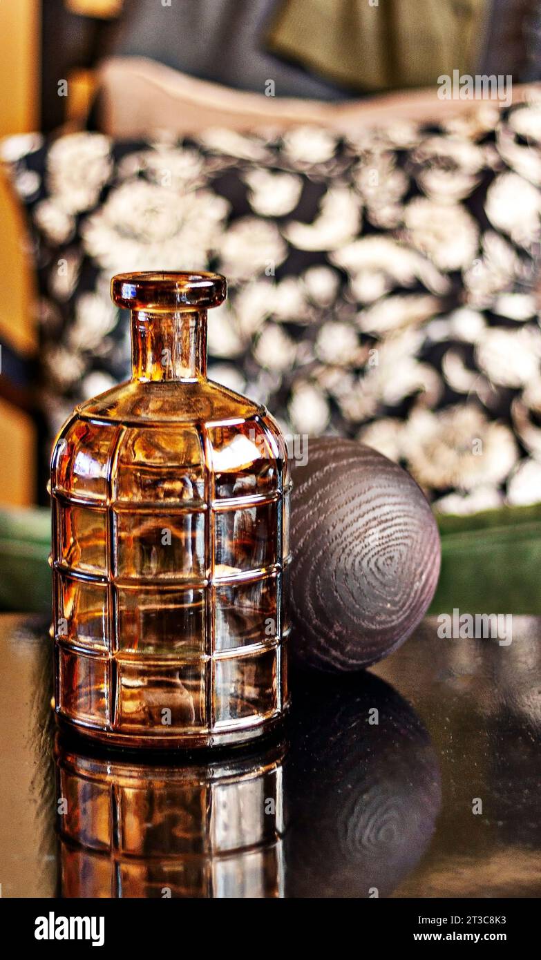 Stillleben mit bräunlichen Requisiten auf dem Holztisch gegen verschwommene Dekokissen Stockfoto