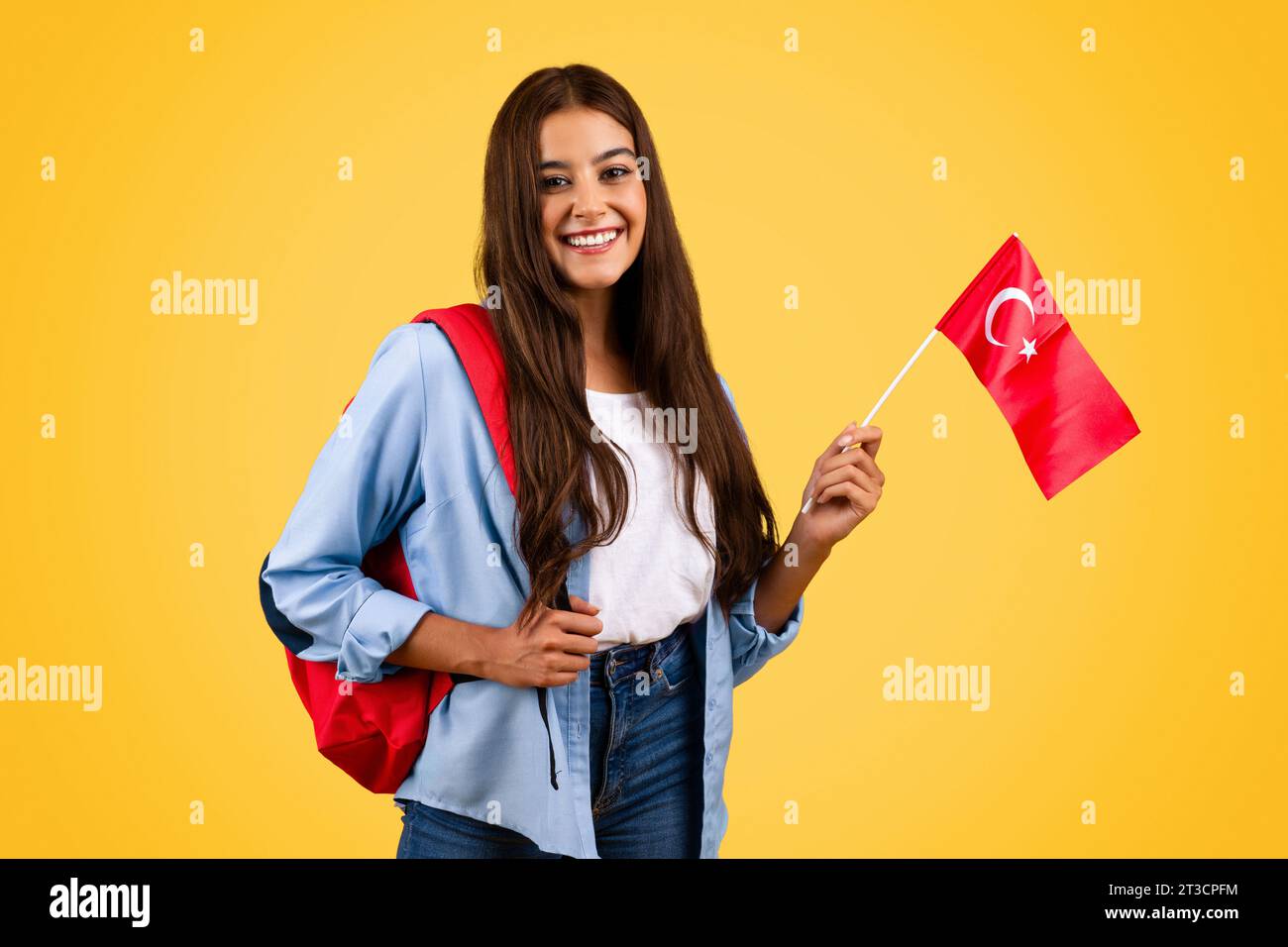 Lächelnde junge europäische Studentin mit türkischer Flagge verbindet Patriotismus mit Bildung Stockfoto