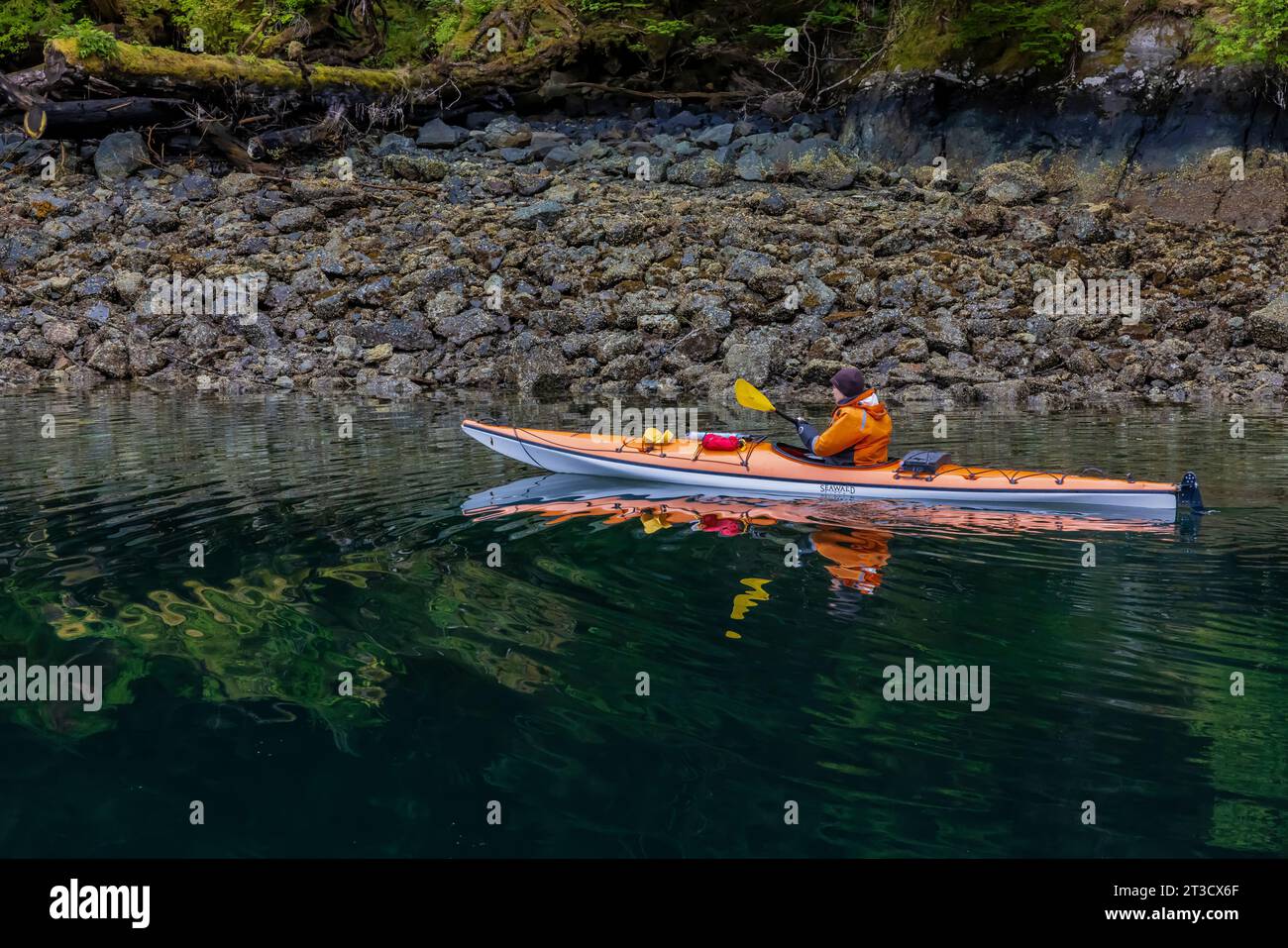 Frau Kajakfahren in der schwimmenden Lodge der Moresby Explorers im Gwaii Haanas National Park Reserve, Haida Gwaii, British Columbia, Kanada [kein Model r Stockfoto