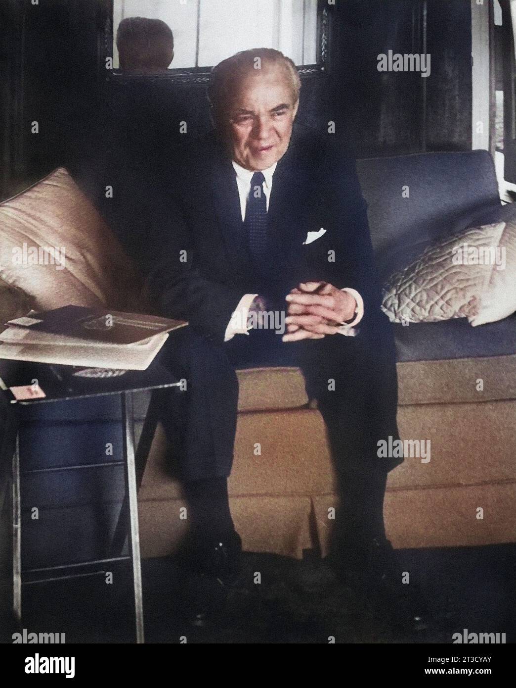 Mittelgroßer Mann im Anzug mit gefesselten Händen auf dem Sofa Stockfoto