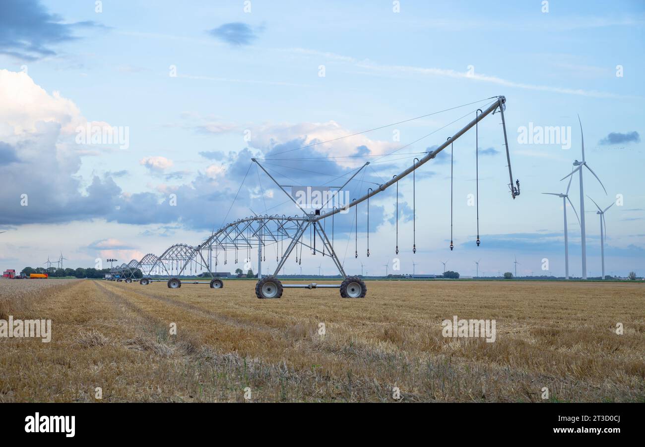 Bewässerungssystem mit Windkraftanlage auf den landwirtschaftlichen Flächen in den Niederlanden Stockfoto