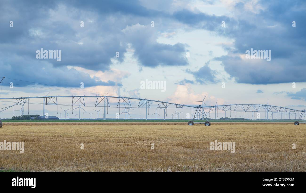 Bewässerungssystem mit Windkraftanlage auf den landwirtschaftlichen Flächen in den Niederlanden Stockfoto