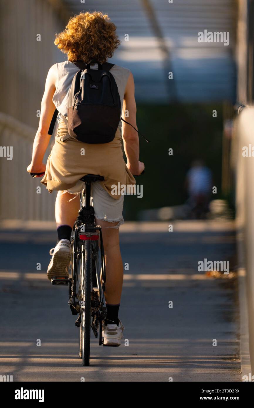 Rückansicht einer jungen Frau, die in der Stadt Fahrrad fährt Stockfoto