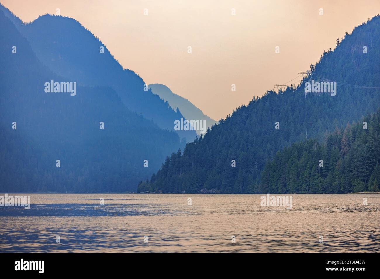 Berge im abgelegenen Indian Arm verblassen in British Columbia, Kanada, in den Himmel. Landschaft von einem Boot auf dem Fjord aus gesehen. Stockfoto