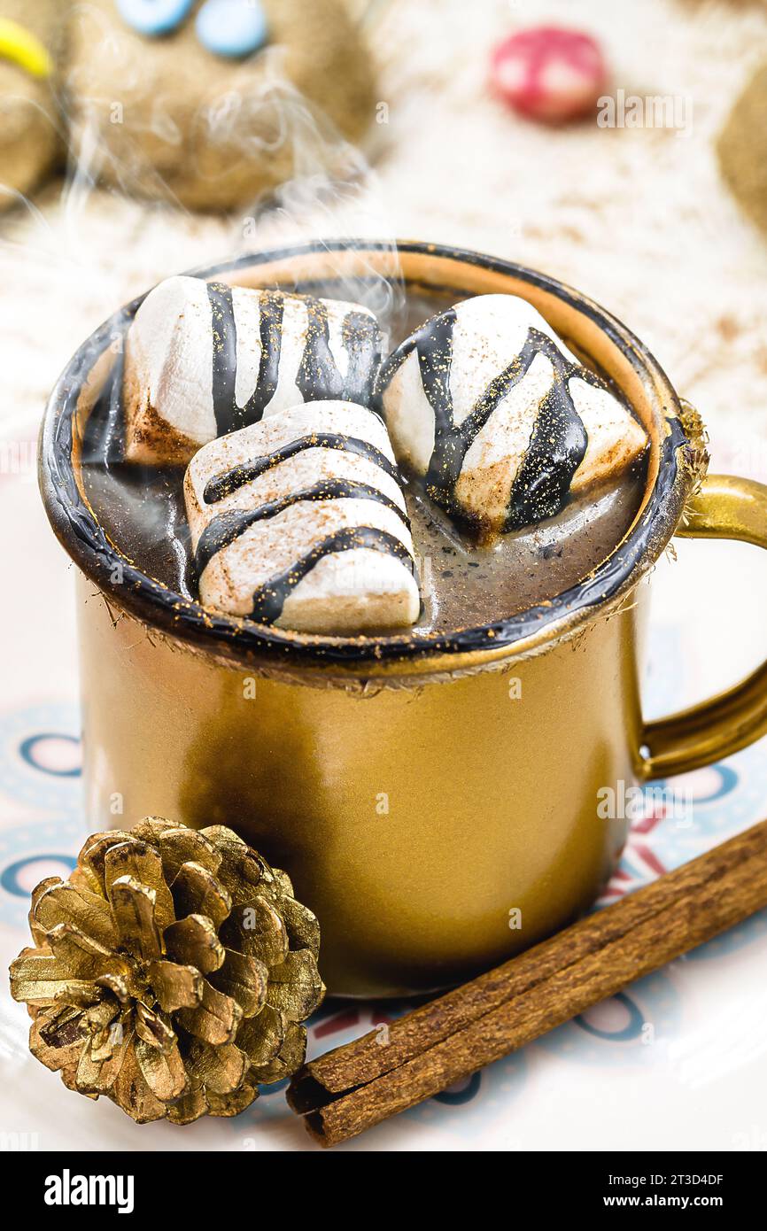 Heiße Schokolade mit Marschmalchen, Dampf oder Rauch, hausgemachtes Weihnachtsgetränk, mit mehreren Lebkuchenmännern auf dem Tisch Stockfoto