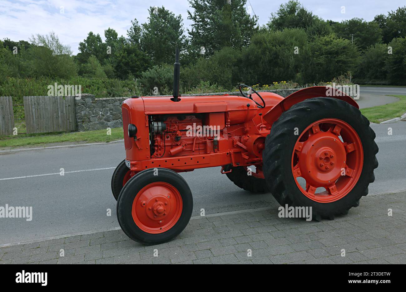 Alter Traktor auf der Straße in roter Farbe. Stockfoto