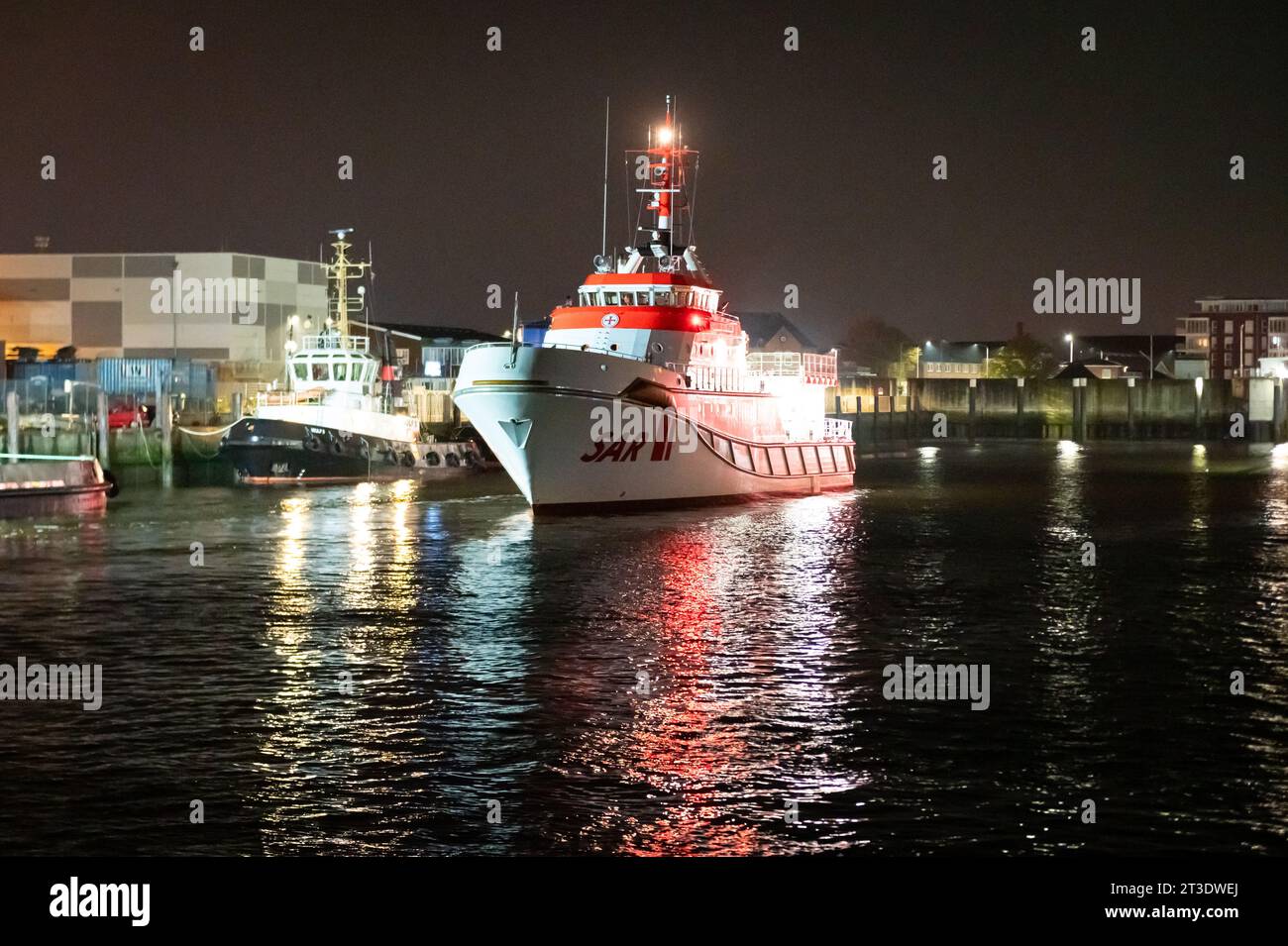 Cuxhaven, Deutschland. Oktober 2023. Der Rettungskreuzer Hermann Marwede der Deutschen Seeschiffssuche und -Rettung (DGzRS) fährt nachts rückwärts in den Hafen. Nach dem Zusammenstoß zweier Frachter in der Nordsee vor Helgoland wurden die vier vermissten Personen der siebenköpfigen Besatzung noch nicht gefunden. Quelle: Jonas Walzberg/dpa/Alamy Live News Stockfoto