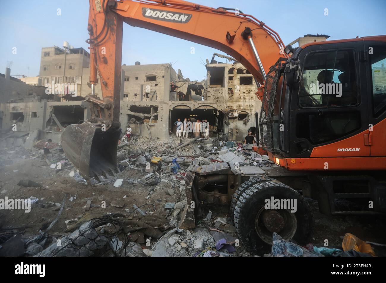 Khan Yunis, Palästinensische Gebiete. Oktober 2023. Ein Bagger räumt Schutt auf, während Menschen nach israelischen Luftangriffen nach Überlebenden durch Gebäude suchen. Quelle: Mohammed Talatene/dpa/Alamy Live News Stockfoto