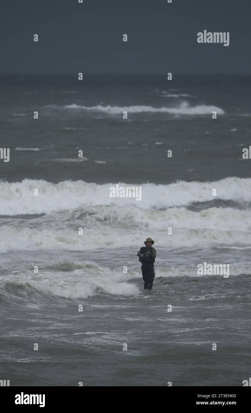 *** STRENG KEINE VERKÄUFE AN FRANZÖSISCHE MEDIEN ODER VERLAGE - RECHTE VORBEHALTEN ***09. Oktober 2023 - Zhuwei, Taiwan: Ein Fischer fischt an einem Strand nördlich von Taipeh, der von Militärexperten als Hauptziel für eine chinesische Militärlandung angesehen wird, wenn sie sich entscheiden, einzumarschieren. Dieser Strand, nur wenige Kilometer vom größten internationalen Flughafen der Insel und etwa 40 Kilometer vom Zentrum Taipeis entfernt, ist einer der sogenannten „roten Strände“ im Zentrum der Verteidigungsstrategie Taiwans. Stockfoto