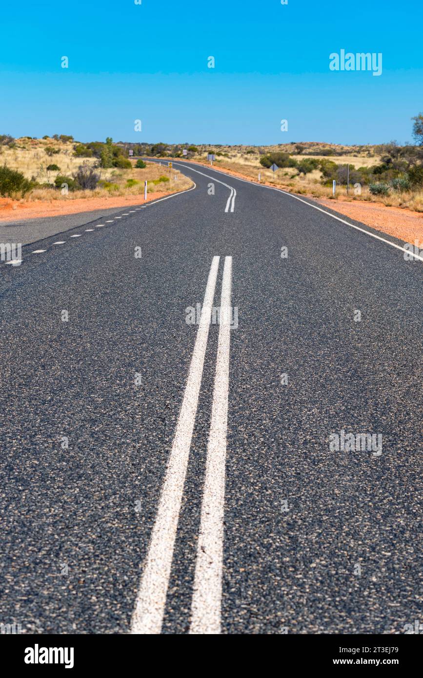 Ein langer gerader Abschnitt des Lasseter Highway zwischen Kings Canyon und Uluru im Northern Territory von Australien Stockfoto