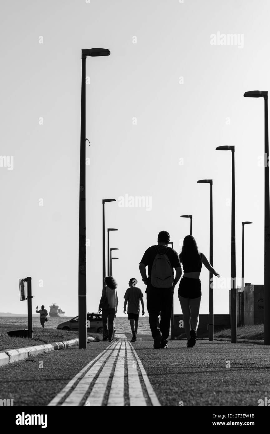 Thessaloniki, Griechenland - 22. September 2023 : Blick auf Menschen und Touristen, die in Richtung der Strandpromenade von Thessaloniki, Griechenland, in Schwarz-weiß laufen Stockfoto