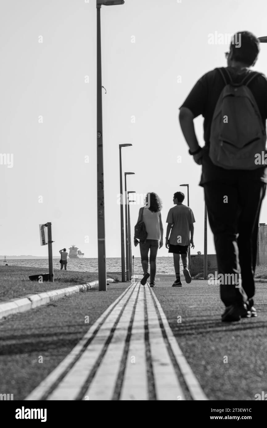 Thessaloniki, Griechenland - 22. September 2023 : Blick auf Menschen und Touristen, die in Richtung der Strandpromenade von Thessaloniki, Griechenland, in Schwarz-weiß laufen Stockfoto
