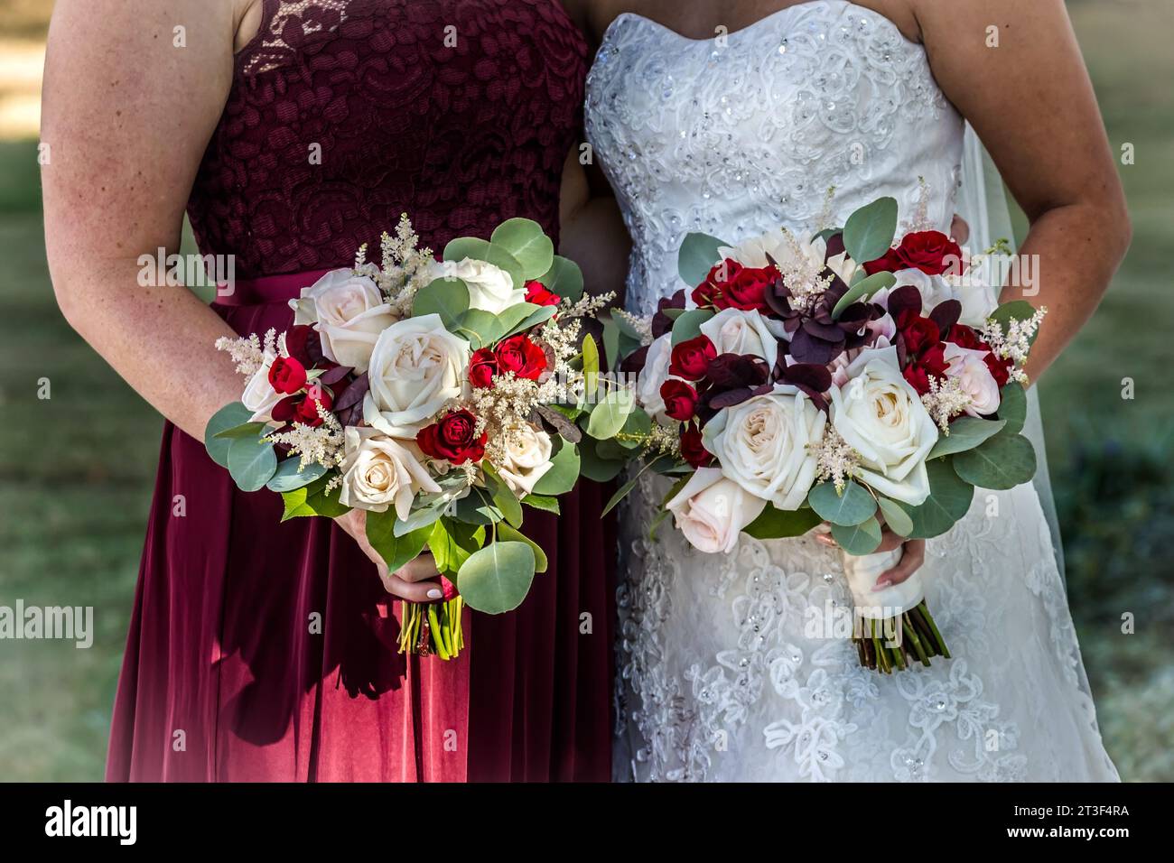 Braut mit Brautjungfer, die Blumensträuße in der Hand hält Stockfoto