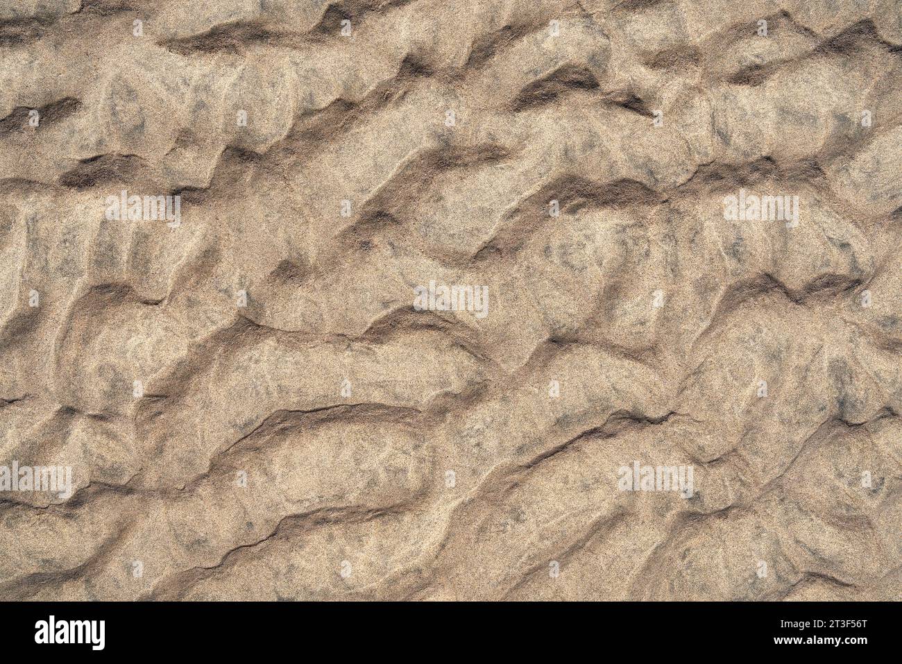 Sandboden in Nahaufnahme gemischt aus braunem und schwarzem Sand Stockfoto