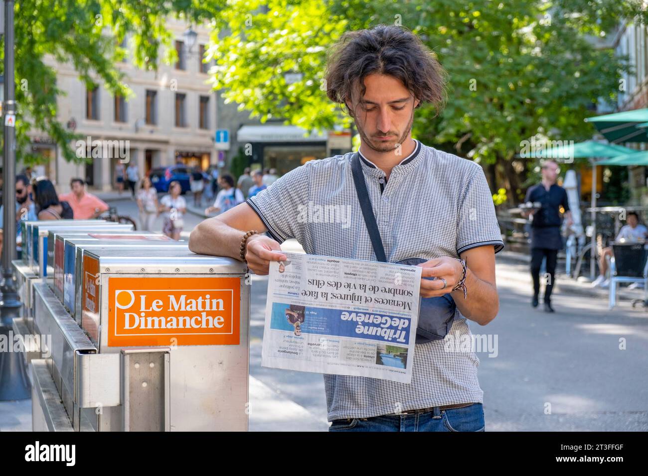 Schweiz, Kanton Genf, Genf, junger Mann, der die Zeitung liest Stockfoto