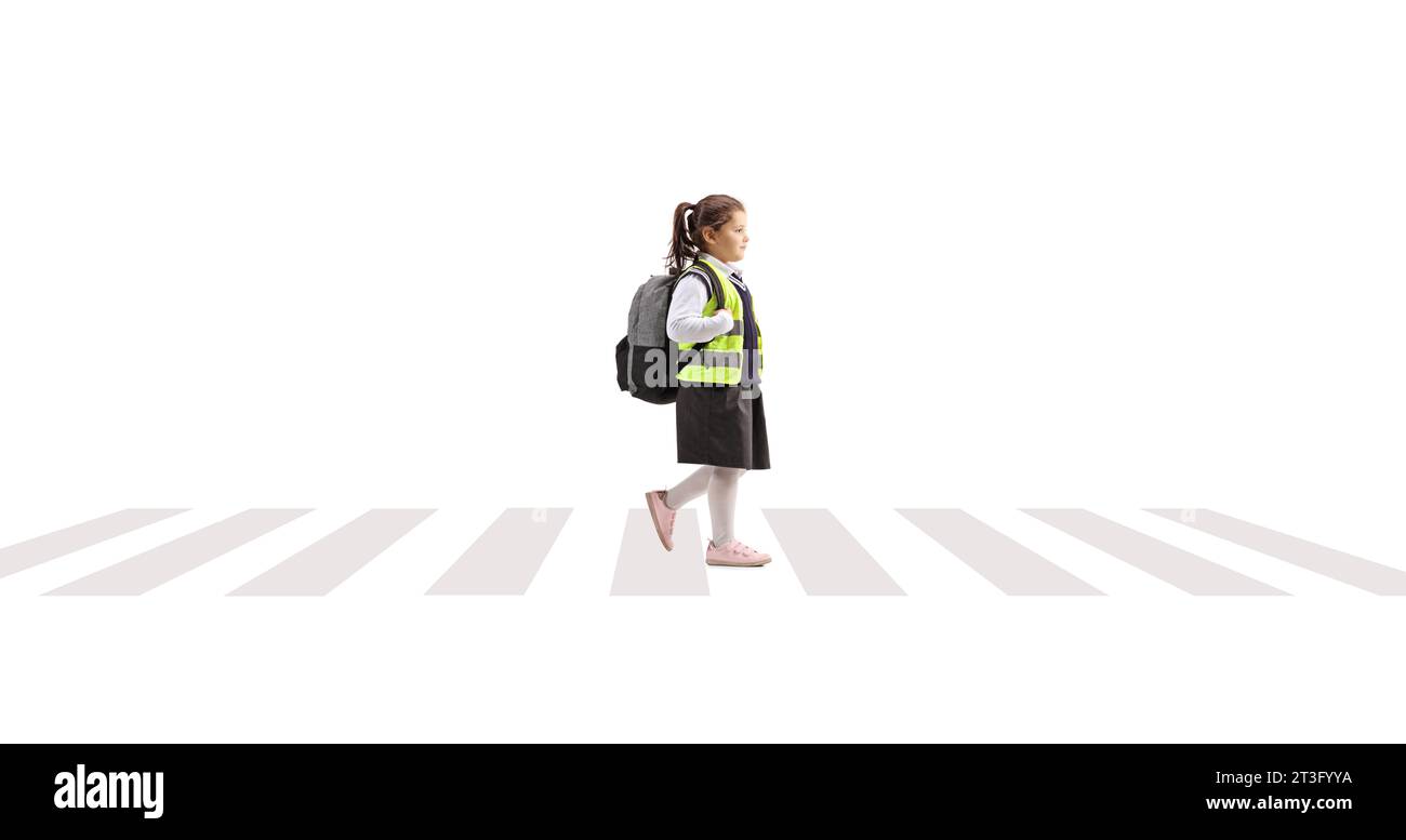 Profilaufnahme eines Schulmädchens, das Sicherheitsweste trägt und eine Straße überquert, die auf weißem Hintergrund isoliert ist Stockfoto