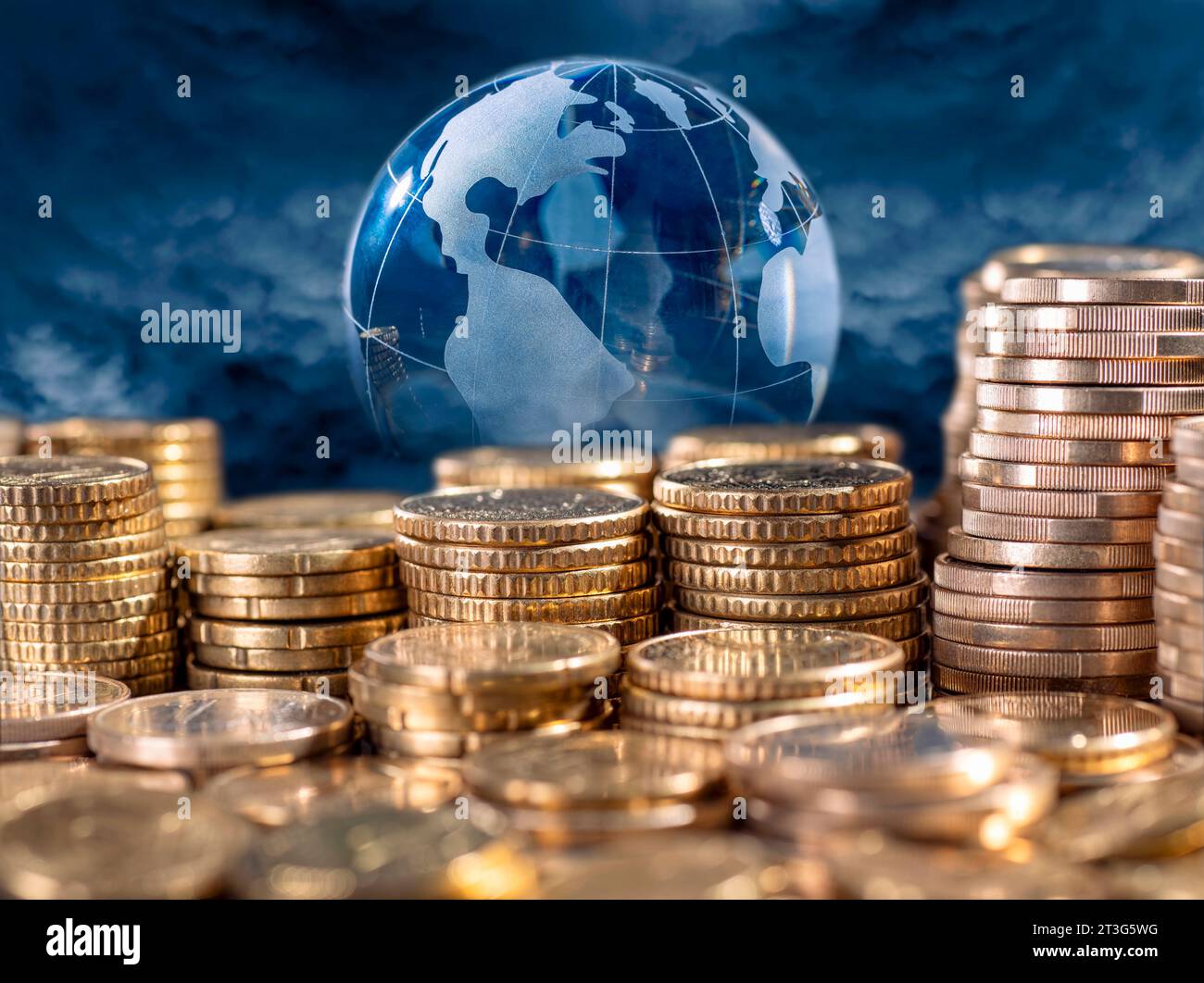 Investieren Sie weltweit Geld. Stapel Münzen und Globus im Hintergrund. Stockfoto