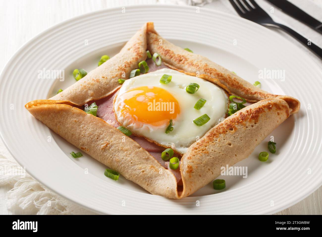 Galette kompletter bretonischer Buchweizen-Pfannkuchen mit Eierkäse und Schinken Nahaufnahme auf dem Teller auf dem Tisch. Horizontal Stockfoto