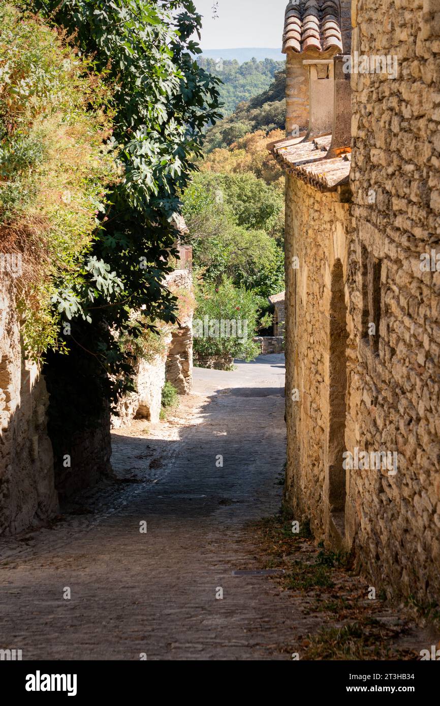 Sommerspaziergang durch die Stadt Gordes auf einer gepflasterten und engen Straße. Stockfoto