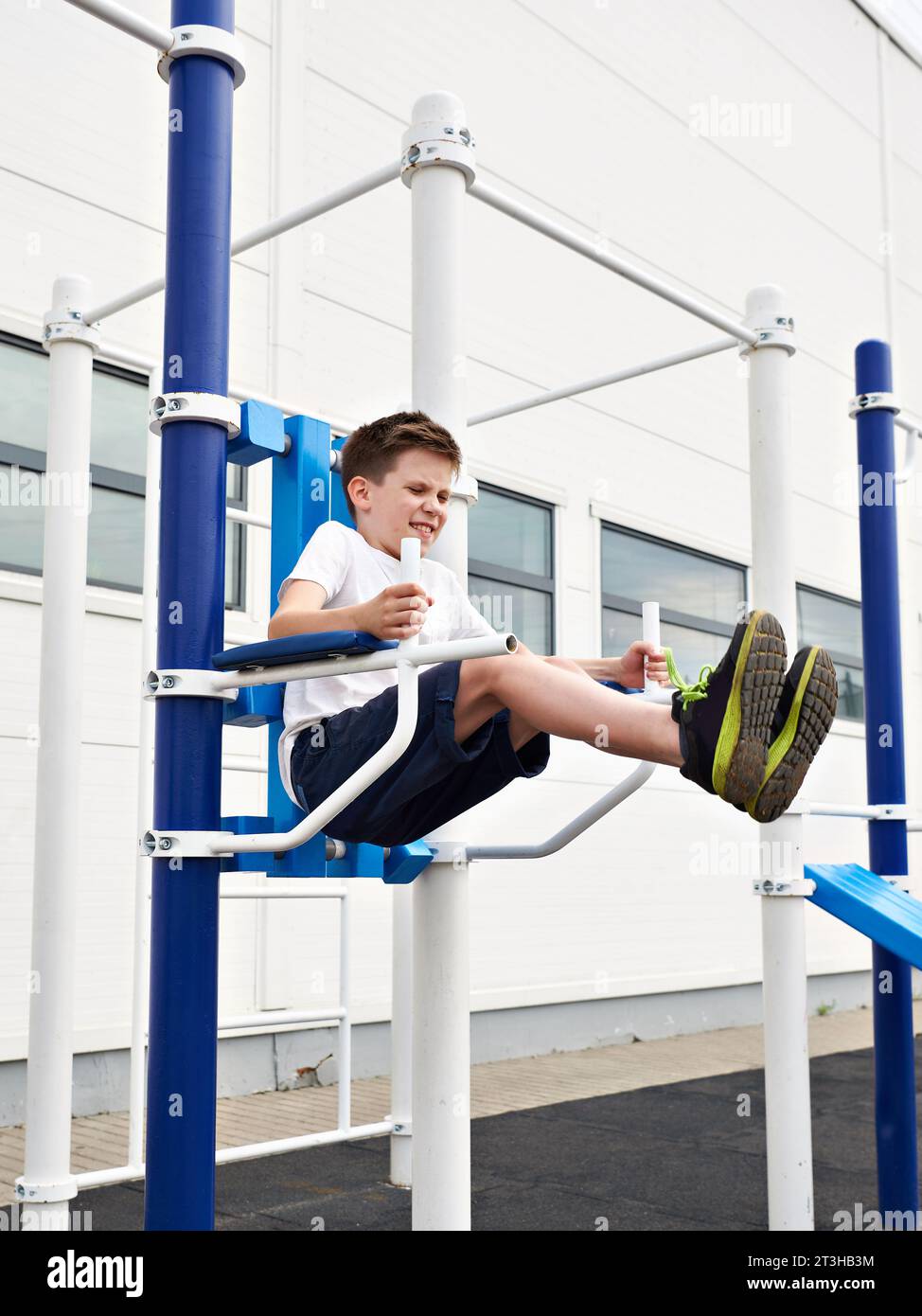 Junge macht Übungen an den Fitnessbars auf dem Sportplatz Stockfoto