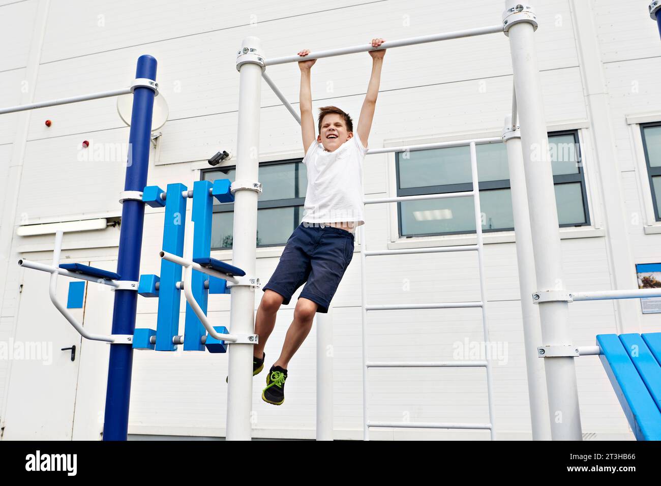 Junge macht Übungen an den Fitnessbars auf dem Sportplatz Stockfoto