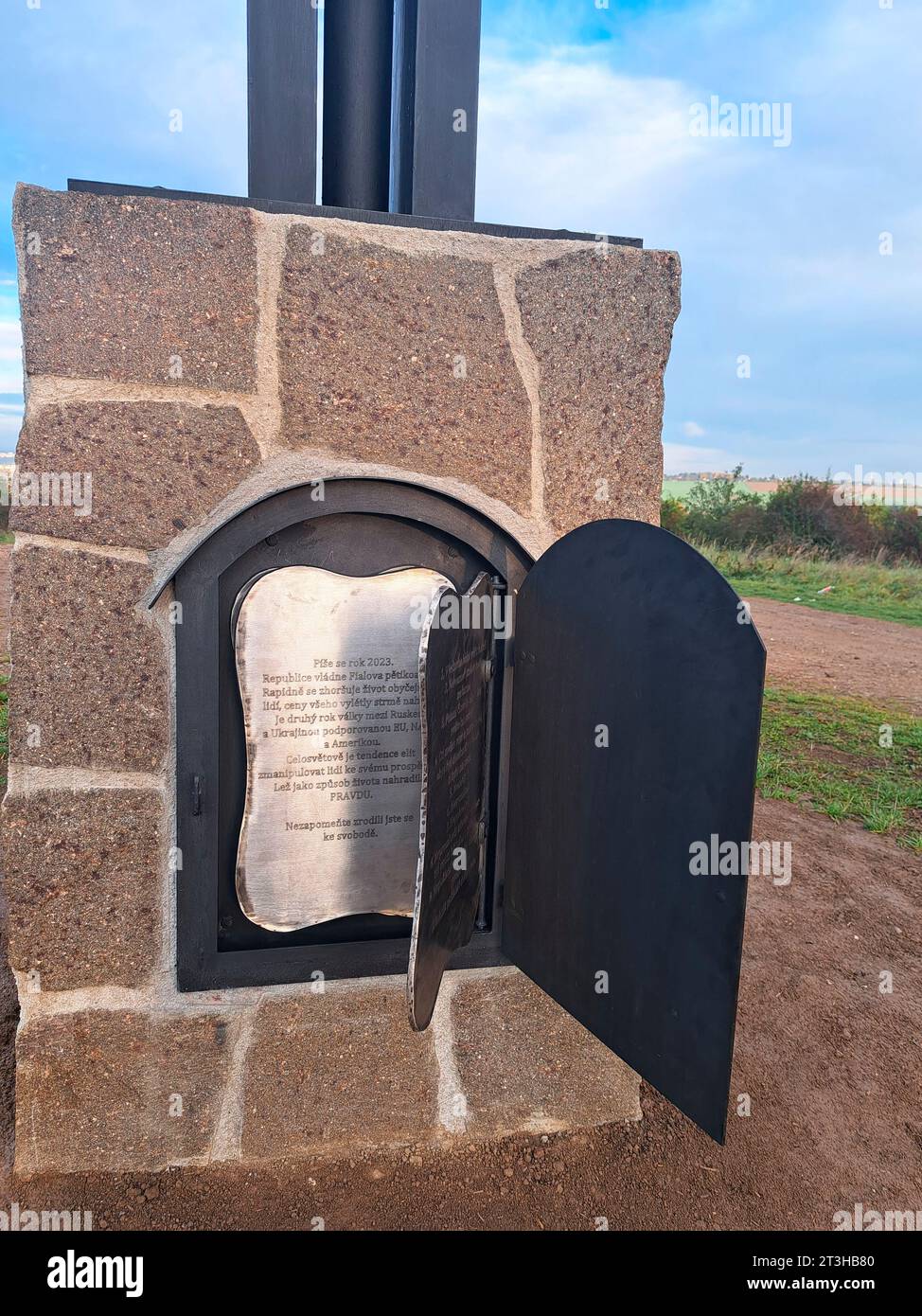 Eine Tür im Steinsockel der geschmiedeten Skulptur der Flügel der Hoffnung am malerischen Aussichtspunkt Koterov über Pilsen, Tschechische Republik, dargestellt am 25. Oktober 2023. Das sieben Meter hohe Werk hat eine Metalltür in einem Steinfuß und dahinter, wie Seiten in einem Buch, drei Edelstahlseiten mit Text, der neben einer Liste der Patroninnen und den zehn Geboten enthält auch eine Beschreibung der Zeit mit Kritik an der Regierung, der NATO und der EU. (CTK Foto/Peskova Lada) Stockfoto