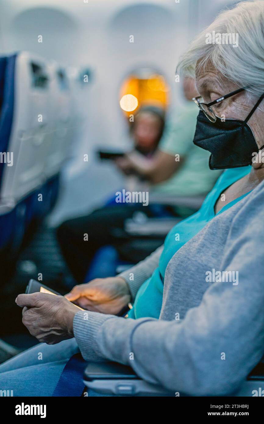 Denver, Colorado - Susan Newell, 74, liest aus ihrem Kindle, während sie auf ihren Flug der Southwest Airlines vom Denver International Airport wartet Stockfoto