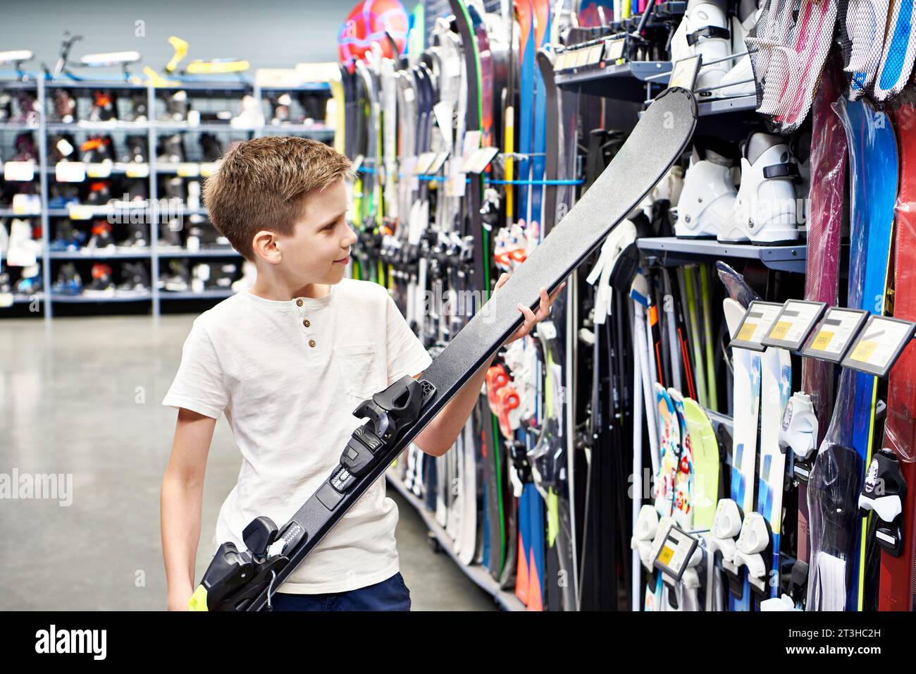 Junge mit Alpinski in einem Sportwarenladen Stockfoto