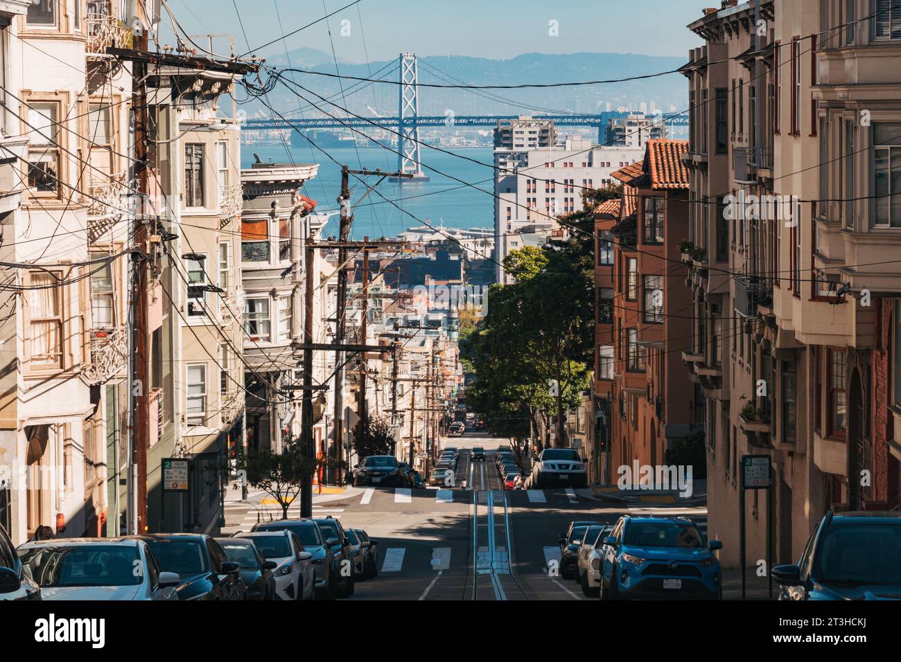 Blick auf die Washington Street, San Francisco, in Richtung der Oakland Bridge, an einem Herbstnachmittag. Stromleitungen wuchern, während Seilbahnschienen parallel verlaufen Stockfoto