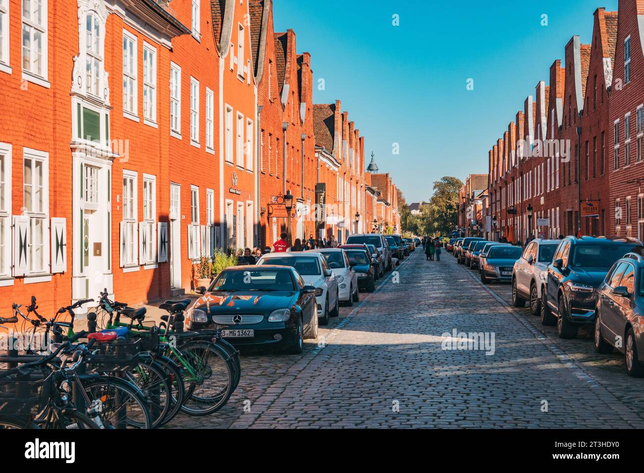 Mit Blick auf die hellen orangen Terrassenhäuser, die die Kopfsteinpflasterstraße der Mittelstraße säumen, Potsdam, Deutschland Stockfoto