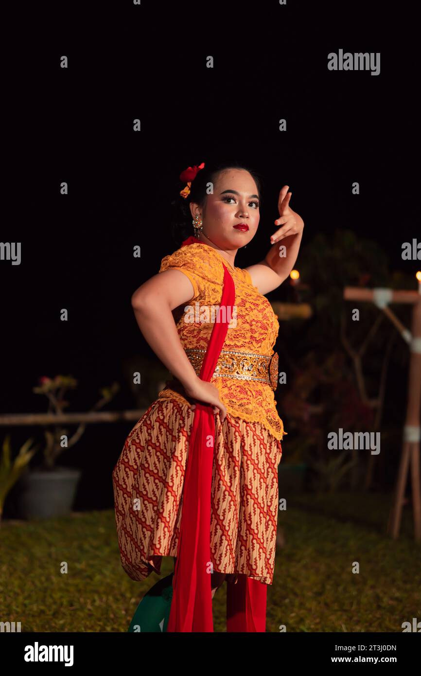 Balinesische Tänzer in gelben Trachten präsentieren den Tanz vor den Besuchern in einer Bali-Tanzvorstellung Stockfoto