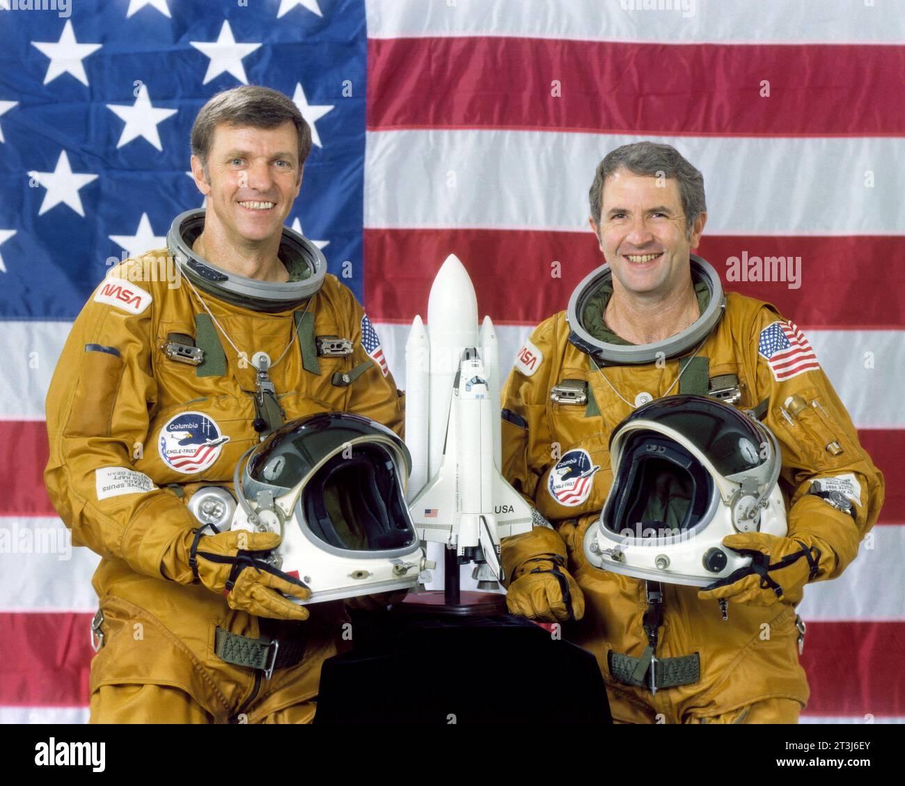 Die STS-2 Prime Crew bestand aus Commander Joe Engle und Pilot Richard, die wirklich vor einer amerikanischen Flagge standen und ihre Helme mit einem Shuttle-Modell auf dem Tisch vor ihnen hielten. Stockfoto
