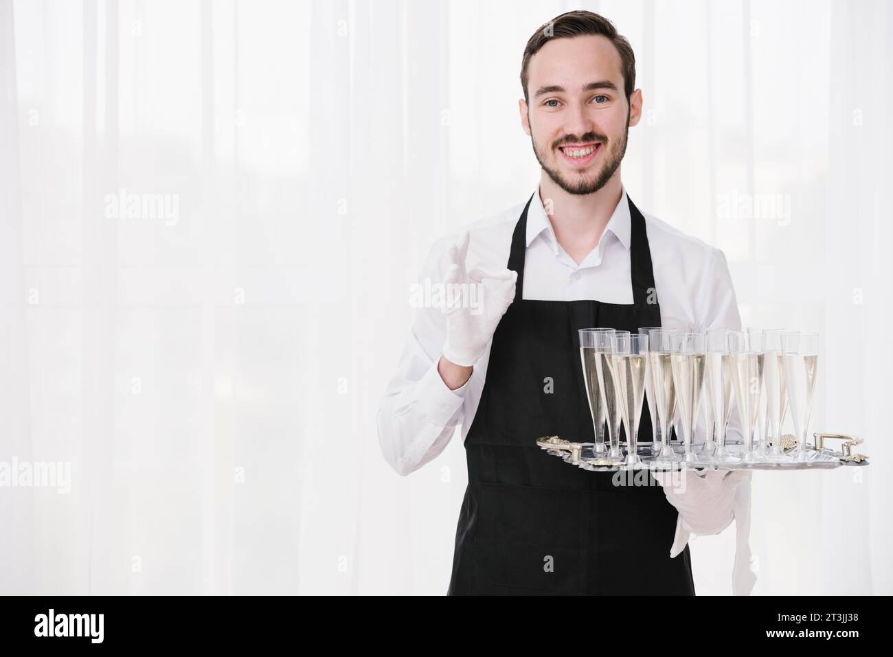 Bärtiger Kellner mit Metalltablett Stockfoto