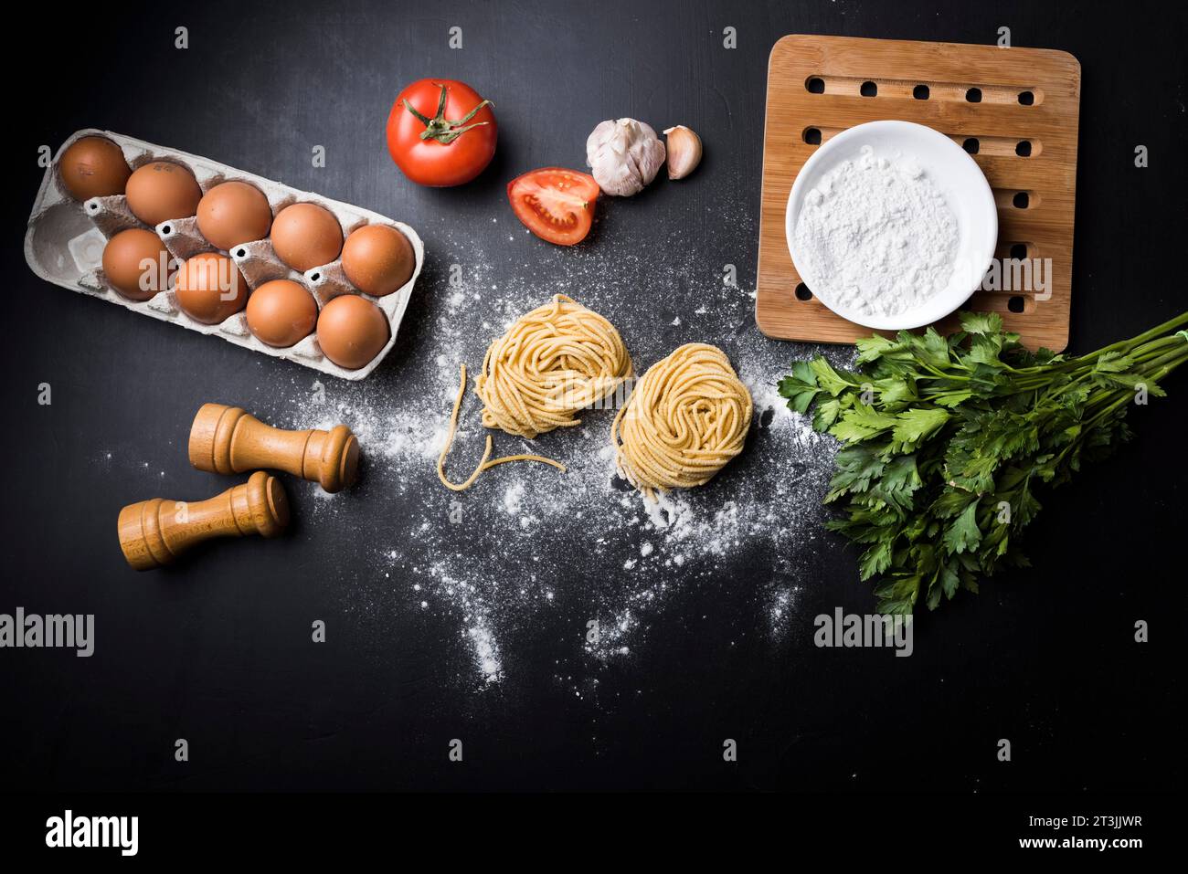 Eierkarton Gemüse Mehl Spaghetti Pasta Nest schwarz Theke Stockfoto