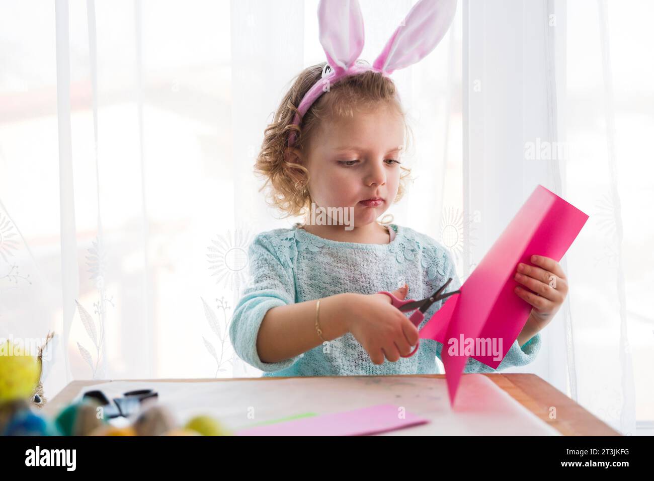 Schönes Mädchen, das osterdekorationen schneidet Stockfoto