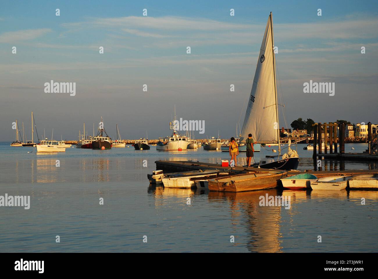 Ein Segelboot liegt am Ende eines Piers in einer ruhigen Bucht Stockfoto