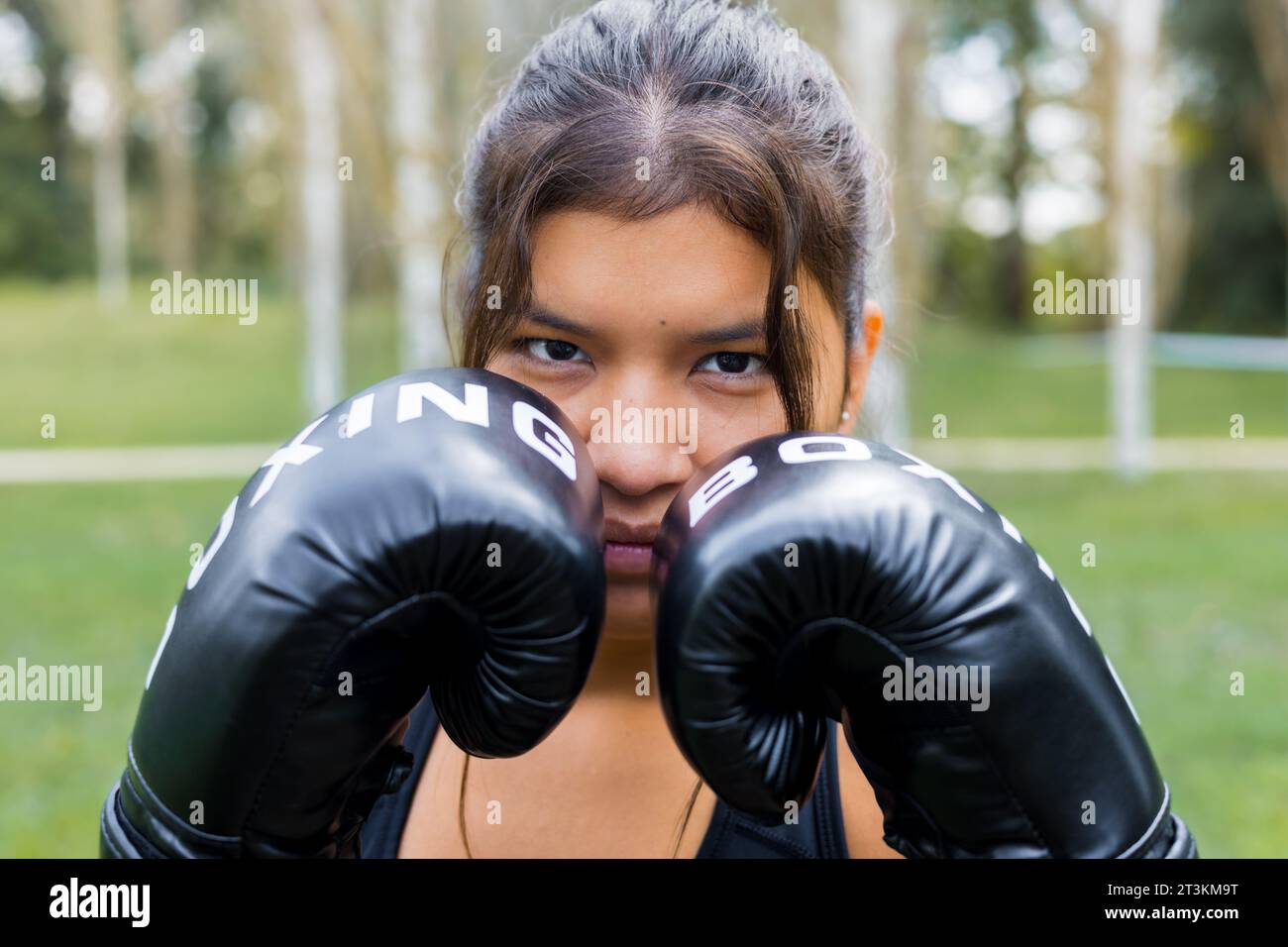 Porträttraining weiblicher latin Boxer mit Boxhandschuhen in Wachstellung. Kampfsport Outdoor-Workout. Stockfoto