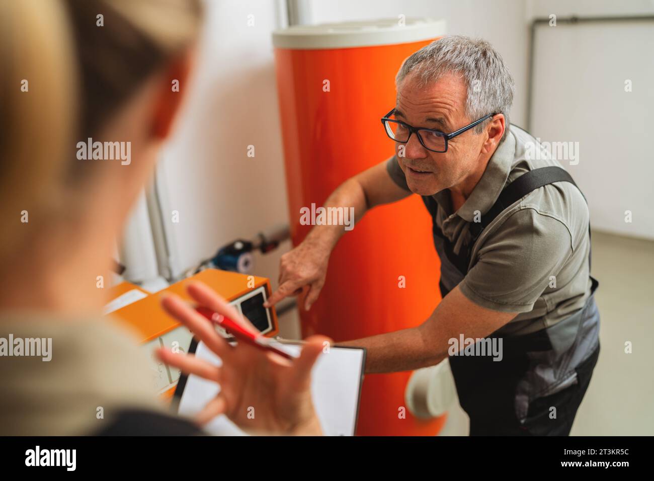 Ein Team von Heizungsingenieuren überprüft eine alte Gasheizung in einem Kesselraum in einem Haus. Bild: Verpflichtung zum Austausch von Gasheizgeräten Stockfoto