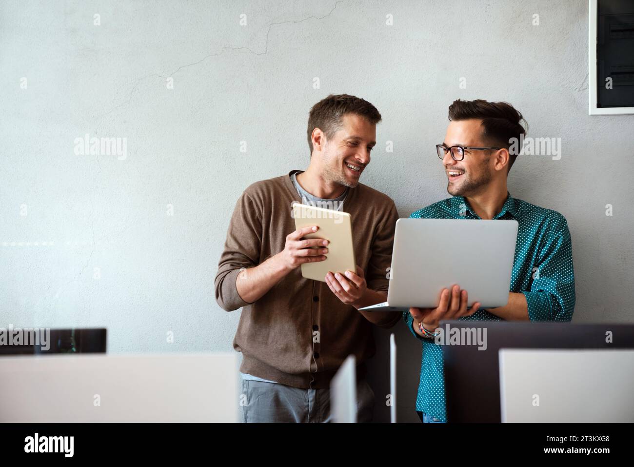 Lächelnd treffen sich verschiedene Kollegen in einem Brainstorming in der Vorstandsetage, um gemeinsam Finanzstatistiken zu diskutieren Stockfoto