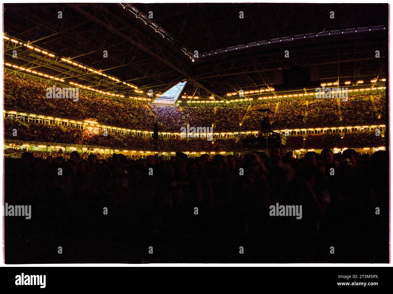 ROBBIE WILLIAMS, CARDIFF, 2001: Die Menge auf den Tribünen des Millennium Stadions mit geschlossenem Dach für den Robbie Williams-Auftritt auf seiner Hochzeiten, Barmitzvahs & Stadiums Tour in Cardiff, Wales, Großbritannien am 14. Juli 2001. Foto: Rob Watkins Stockfoto