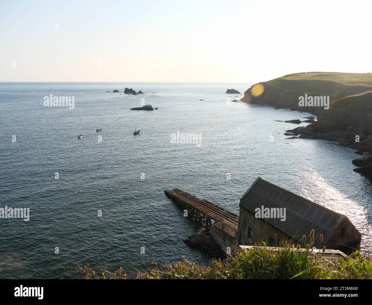 Isolierte Felsen im Meer vor der Klippe am Lizard Point in Cornwall, England bei Sonnenuntergang Stockfoto