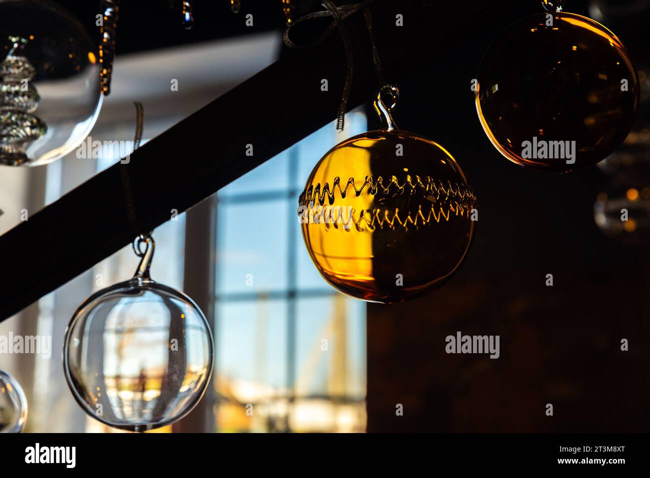 Weihnachtsdekoration hängt in einem dunklen Innenraum, transparente Glaskugeln Stockfoto