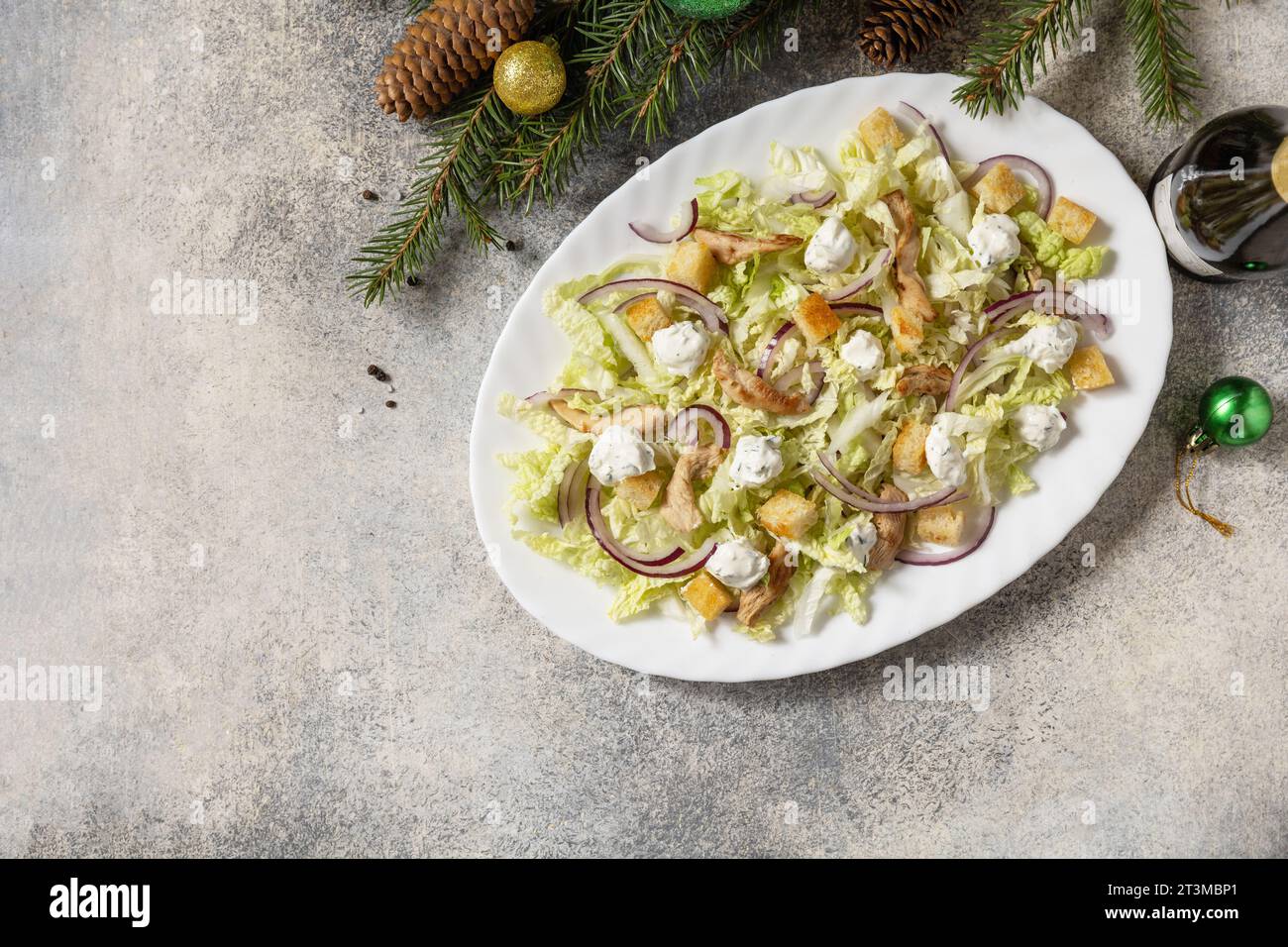 Vorspeise zu Weihnachten. Weihnachts-Neujahrssalat chinakohl, Fetakäse, Huhn und Croutons auf dem festlichen Tisch. Blick von oben. Kopierbereich. Stockfoto