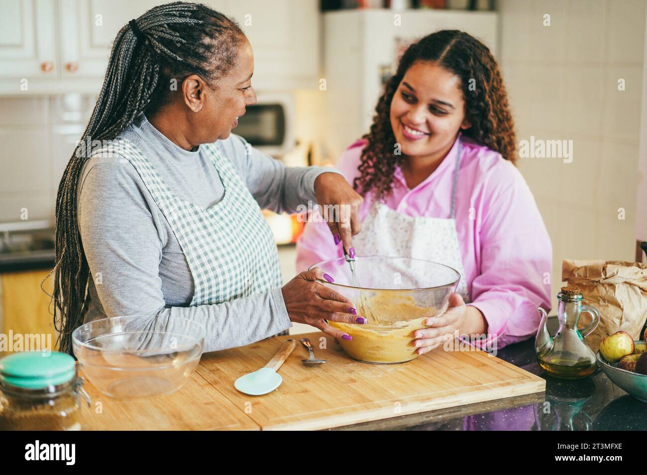 Afrikanische Mutter und Tochter bereiten gesunden Kuchen zu Hause - Backen, Familie Lifestyle Konzept - Fokus auf Mamas Gesicht Stockfoto