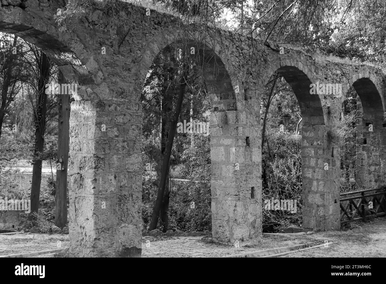 Aquädukt, ein Wasserkursbogen über dem Rodini Park See und Wanderweg im Zentrum von Rhodos. Schwarz-weiß Stockfoto
