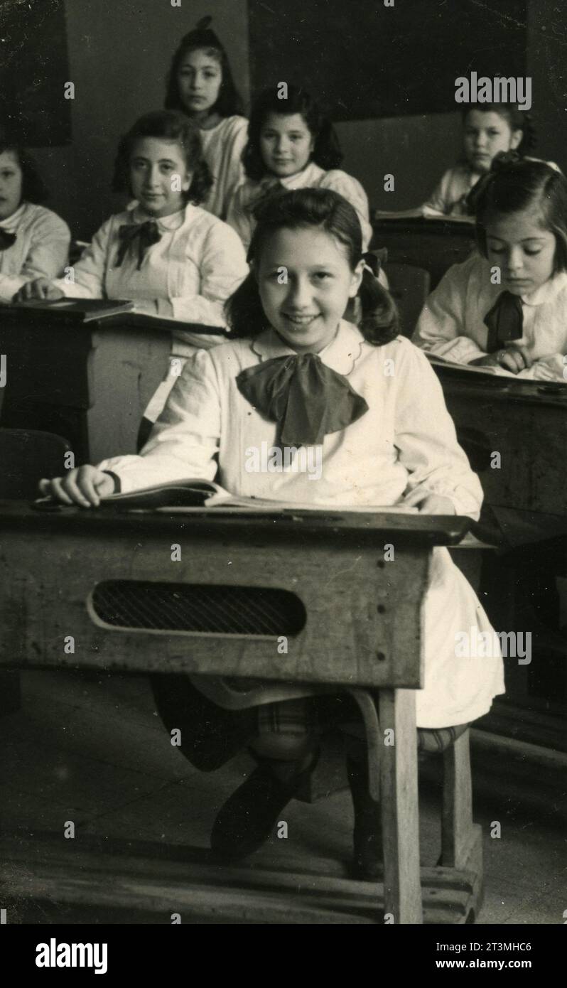 Klassenfoto von Mädchen mit Schürze und Schleife im Klassenzimmer, Italien 1960er Jahre Stockfoto