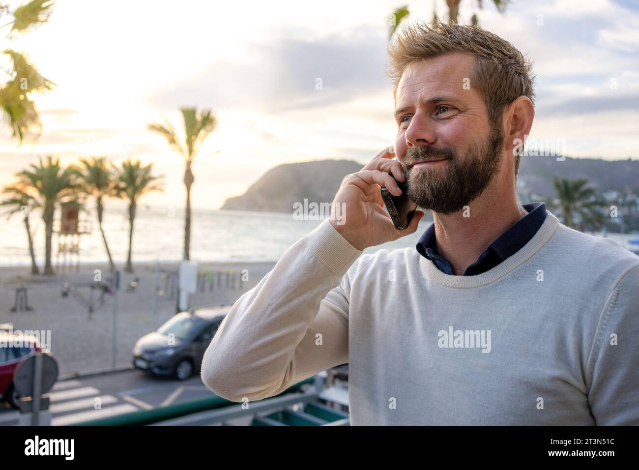 Mann am Smartphone - junger Geschäftsmann, der mit dem Smartphone spricht. Lässiger, städtischer Geschäftsmann mit Handy lächelnd, glücklich zu Fuß. Stockfoto