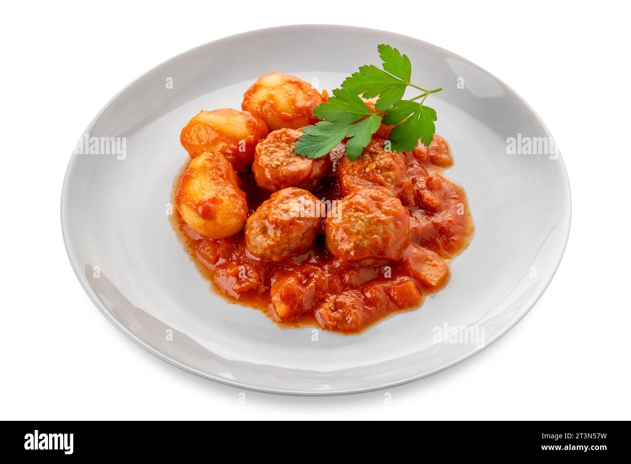 Fleischbällchen und Kartoffeln mit Tomatensauce mit Petersilienblättern auf weißer Platte isoliert auf weiß mit Schnittpfad im Preis inbegriffen Stockfoto