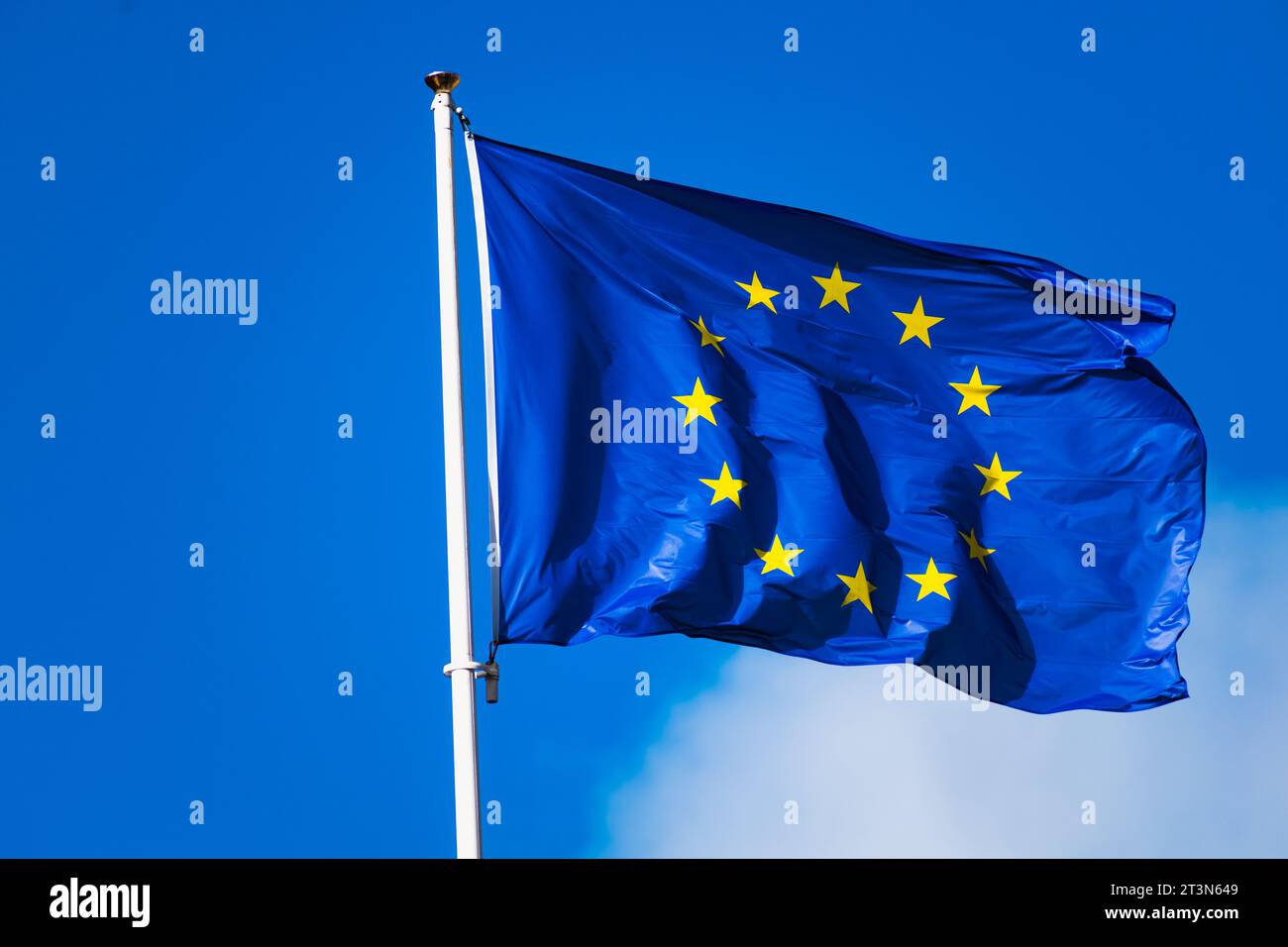 Europaflagge flattert mit starkem Wind und blauem Himmel, blaue Flagge mit gelben Sternen, die einen Kreis bilden Stockfoto