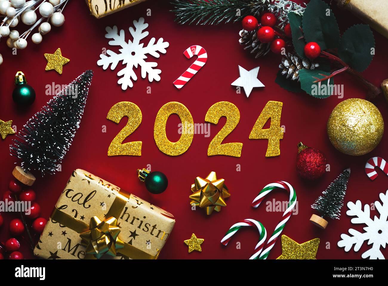 Frohes neues Jahr 2024. weihnachtsschmuck von oben und goldene Zahlen mit der Zahl 2024 auf rotem Hintergrund. Silvesterfeier Konzept Backgr Stockfoto
